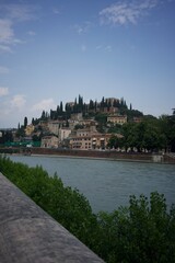 Fototapeta premium River view of a hill with buildings in Verona