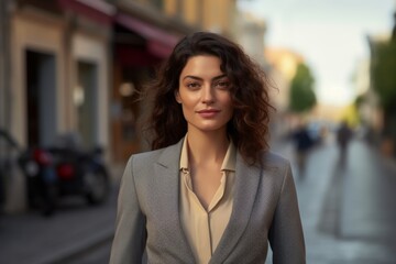 A woman in a business suit is walking down a street