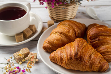 Tea with croissants on a light table. Sweet breakfast