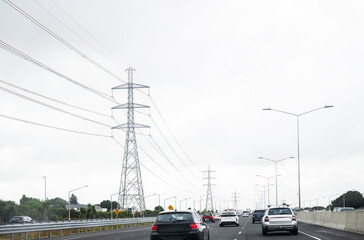 Transmission pylons and power lines along the busy motorway. Auckland.