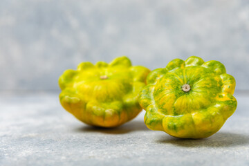 Pattypan zucchini on a textured kitchen table. squash. Fresh organic pattypan squashes on...