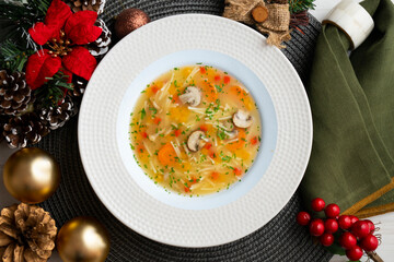 Short noodle soup with vegetables and mushrooms. Top view table with Christmas decoration.