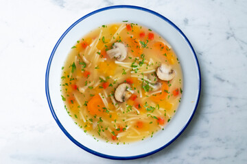 Short noodle soup with vegetables and mushrooms. Top view table with  decoration.