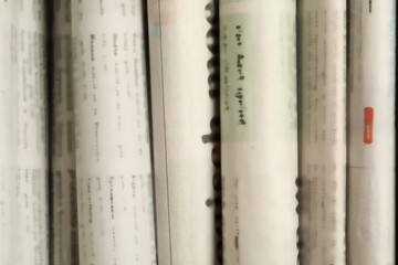 Many newspapers in different languages as background, closeup