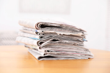 Stack of many newspapers on wooden table