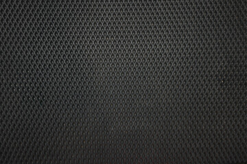Black rubber car mat as background, top view
