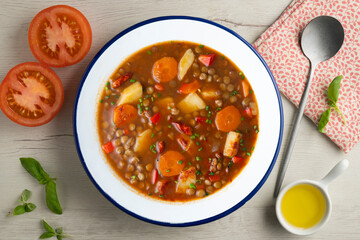 Spicy stewed lentils with vegetables and potatoes. Top view table with decoration.