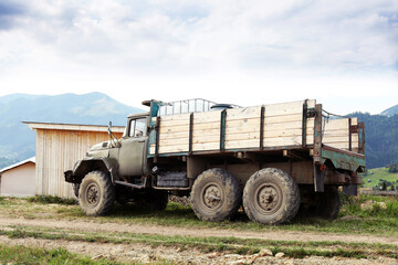 Obraz premium Farming equipment. Old truck in farm near mountains