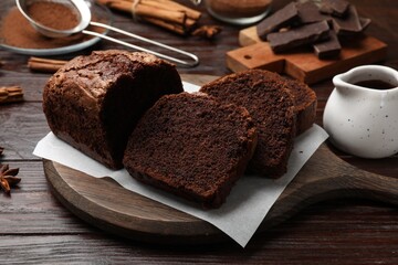 Delicious cut chocolate sponge cake on wooden table, closeup
