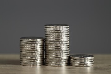 Stacked coins on wooden table against grey background, closeup. Salary concept