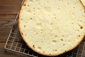 Tasty cut sponge cake on wooden table, closeup