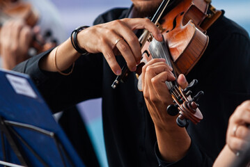 Close-up of violinist's hands in orchestra
