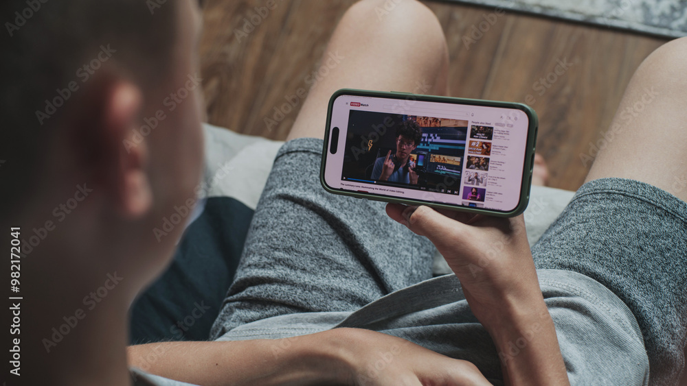 Aufkleber video sharing platform with blogger content about video editing displayed on smartphone screen. clos