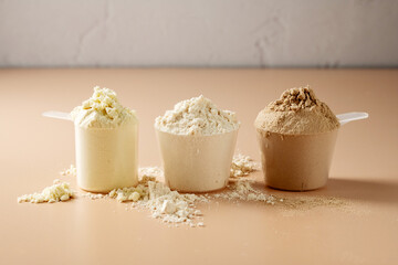 Protein powder in scoops. Different flavours of whey protein powders