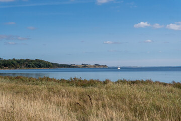 A boat is sailing in the ocean near a shore