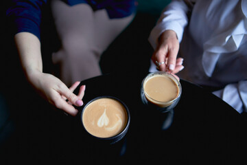 old mother and middle-aged daughter drinking coffee and talking in the cafe