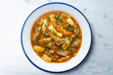 Squid stew with potatoes, artichokes and vegetables. Top view table with  decoration.