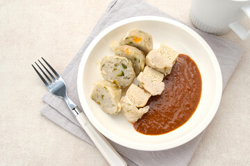 Siomay Bandung (Shumay) or steamed dumplings with boiled tofu. Indonesian traditional street food with peanut sauce.

