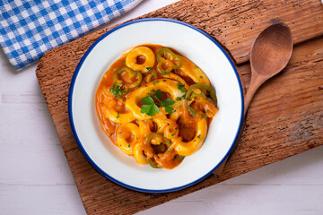 Squid stew with potatoes, artichokes and vegetables. Top view table with  decoration.