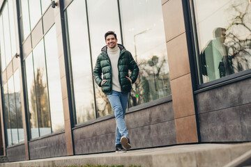 Photo of positive cheerful handsome man walking city center spring day outdoors © deagreez