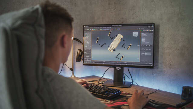 Young designer creates 3D model and animation of the robot dog using PC. Interface of professional 3D modeling software. Teenage boy working remotely on freelance project on computer at home.