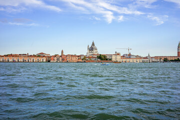 Obraz premium A panoramic view of Venice, Italy, featuring the Grand Canal and historic architecture under a clear sky. This image is ideal for travel promotions, postcards, or scenic cityscape backdrops.