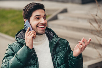 Photo of attractive glad man speaking phone with friend pastime weekend vacation autumn day outdoors