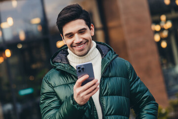 Fototapeta premium Photo of happy handsome man walking traveling city street reading news in cold autumn weather outdoors