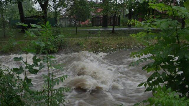 Tilt shot of strong current and houses next to the river