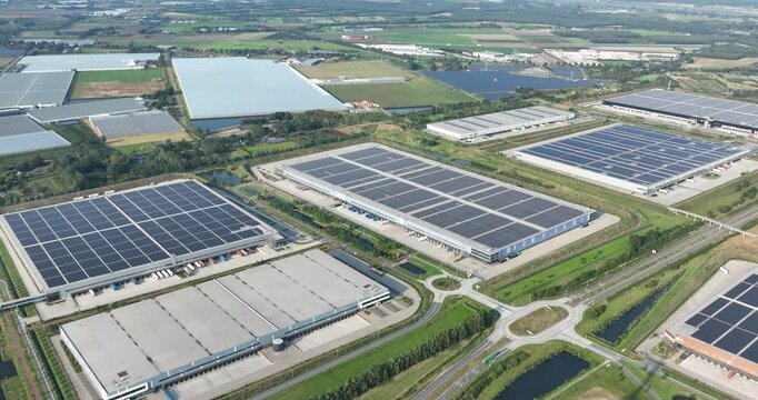 Business park in Venlo, modern distribution centers solars panels on the roof. Aerial drone video