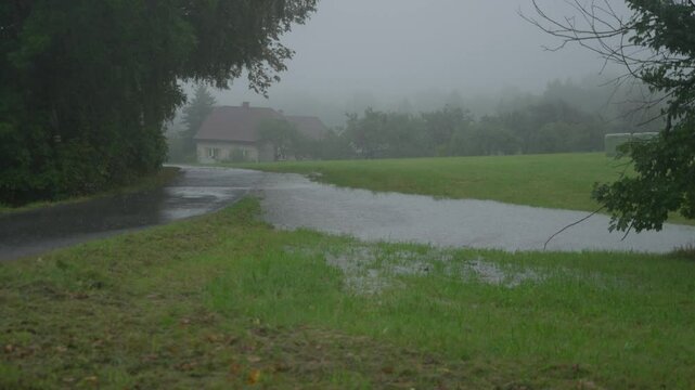 Wide static shot of flooded road and field