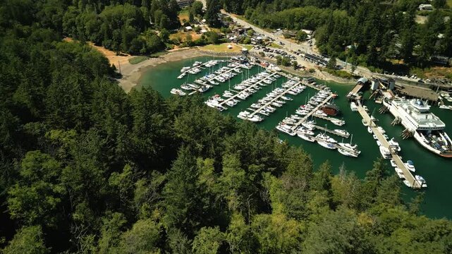 Drone flying over a small tropical local boat port with lots of boats and yachts anchored in the tropical blue clear water parked perfectly and symmetically
