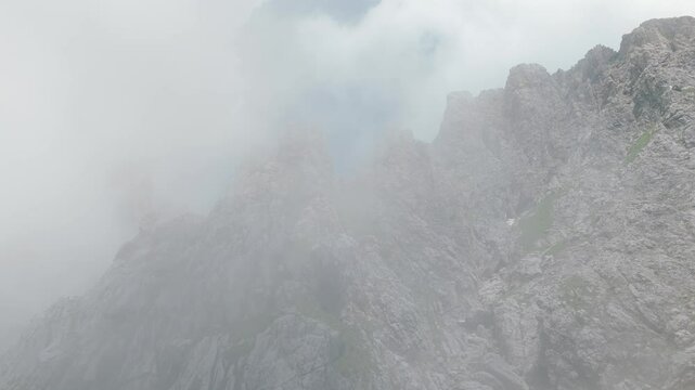 Lombardy, Italy - A Captivating View of Grignetta's Mountain Peaks Shrouded in Fog - Aerial Drone Shot