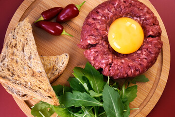 Tartar with egg and arugula. fresh ground meat with seasonings. fresh greens.