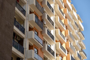 A tall building with windows, next to which workers stand on a crane. High quality photo