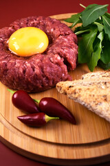 Tartar with egg and arugula. fresh ground meat with seasonings. fresh greens.