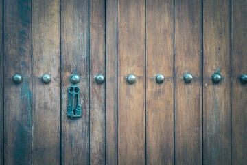 Vintage wooden door decoration with a beautiful carved pattern on the top of the door. Antique old door retro style.