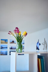  bouquet of multicolored tulips in a transparent jar in the interior
