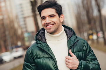 Photo of cheerful attractive man walking on city street excursion in cold autumn weather outdoors © deagreez