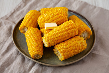 Homemade Organic Steamed Yellow Sweet Corn on the Cob with Butter, side view.