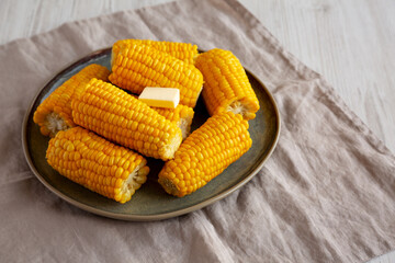 Homemade Organic Steamed Yellow Sweet Corn on the Cob with Butter, side view. Copy space.