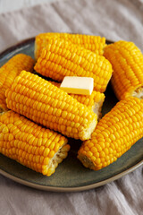 Homemade Organic Steamed Yellow Sweet Corn on the Cob with Butter, side view.