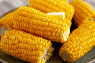 Homemade Organic Steamed Yellow Sweet Corn on the Cob with Butter, side view. Close-up.