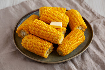 Homemade Organic Steamed Yellow Sweet Corn on the Cob with Butter, side view.