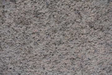 Close up of gray wall with unpainted cement roughcast finish
