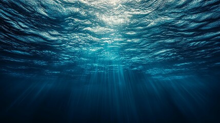 Underwater view of sunbeams penetrating the ocean surface