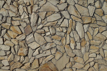 Texture of wall made of beige natural shape fieldstones