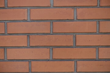 Closeup of red smooth brick wall with standard stretcher bond