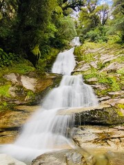 Obraz premium Long exposure image of Depot Creek Falls in Haast, South Island, New Zealand. Waterfall in the forest