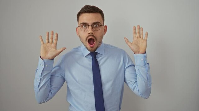 Young hispanic man wearing shirt and tie with mouth open in surprise and amazement, standing over isolated white background, showing a face of fear and disbelief